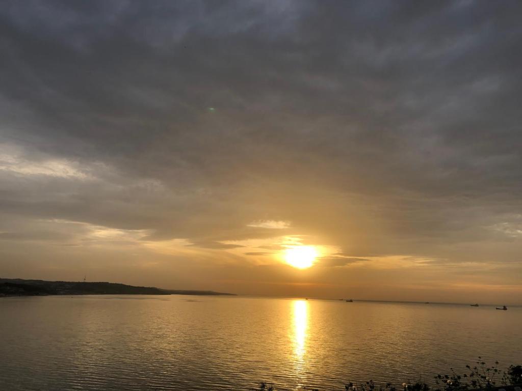 a sunset over a large body of water at Erzurumlu Hotel in Kilyos