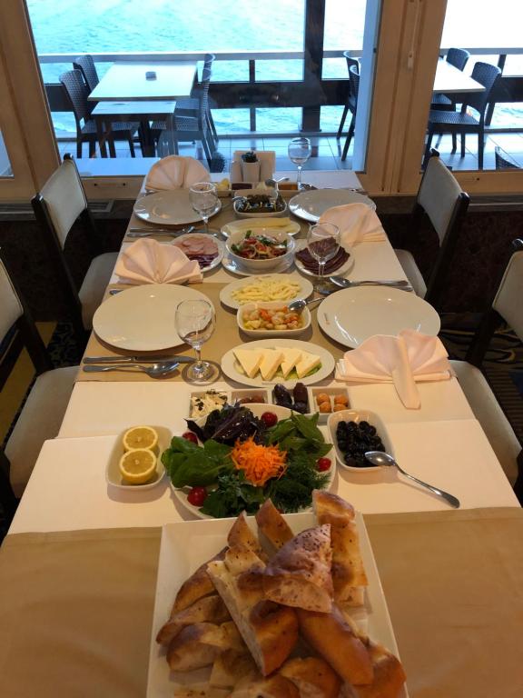 a long table with plates of food on it at Erzurumlu Hotel in Kilyos