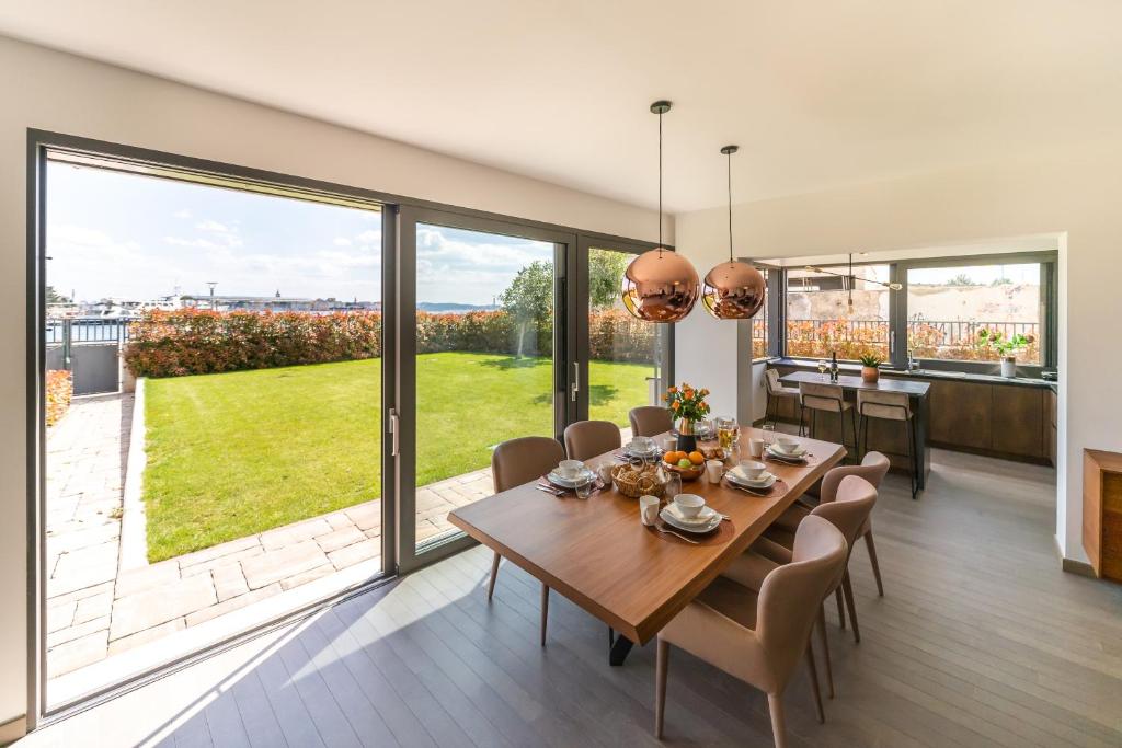 a dining room with a table and chairs and large windows at UNIQUE LUXURY DESIGNERS APARTMENT in Zadar