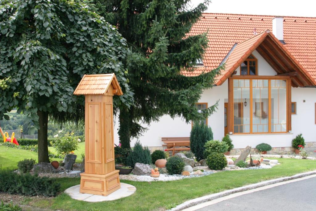 a house with a garden with a wooden structure at Schwalbenhof - Urlaub am Bauernhof in Sankt Stefan im Rosental
