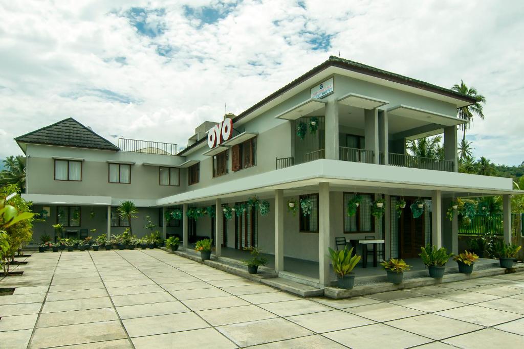 un gran edificio con un patio delante de él en OYO 882 Puri Gevana Guest House en Padang
