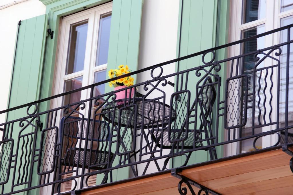 - Balcón de hierro forjado con sillas y ventana en Pension Isabo, en Nauplia