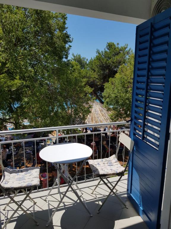 uma mesa e cadeiras numa varanda com uma montanha-russa em Adriatic Blue View em Drvenik