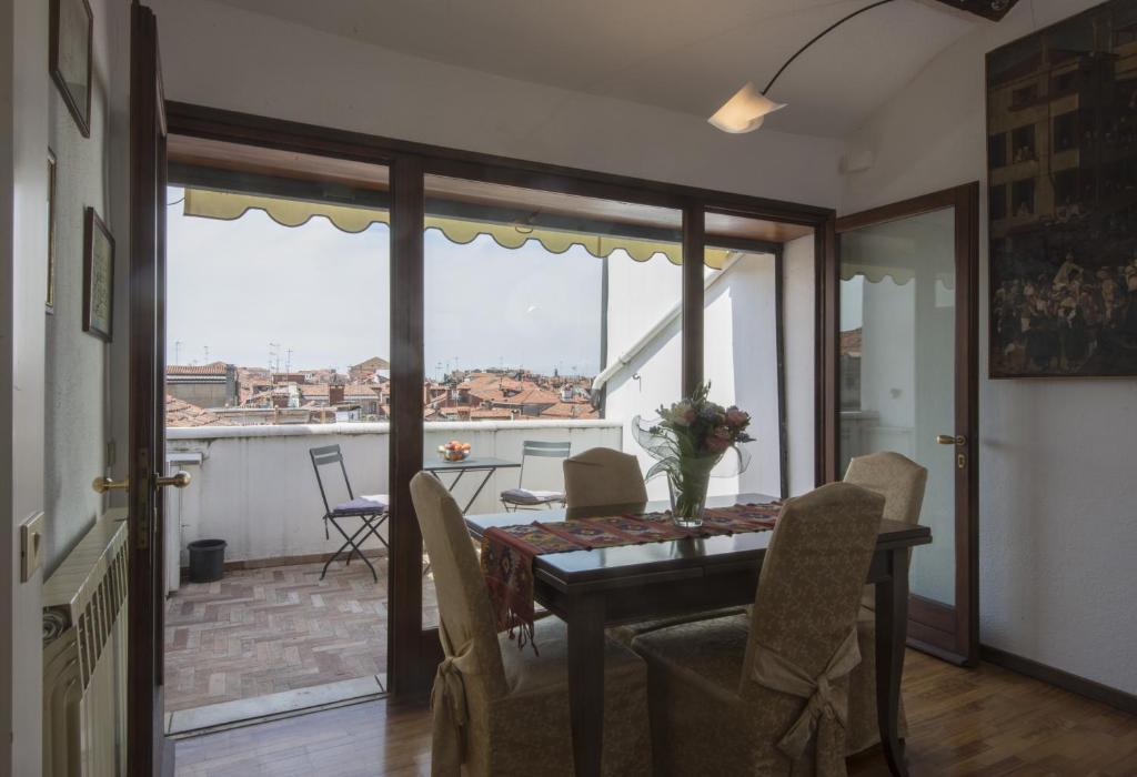a dining room with a table and chairs and a balcony at Ca'Baloni in Venice