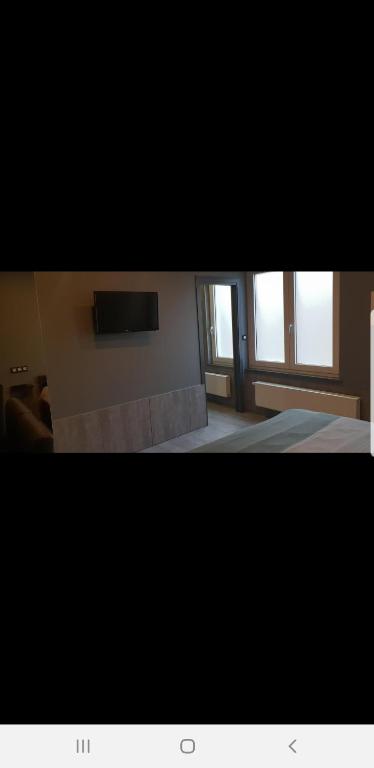 a view of a bedroom with a bed and windows at Appartement Studio Tournai in Tournai