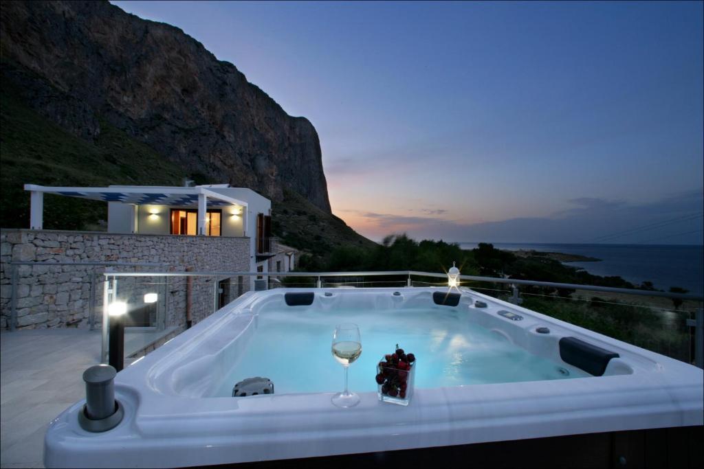 a jacuzzi tub with a glass of wine at Villa Antonia - Vasca Idromassaggio Terrazza Vista Mare in San Vito lo Capo