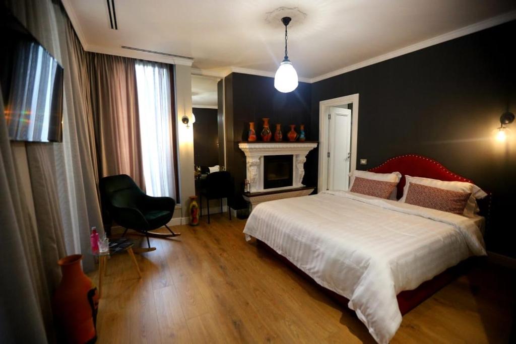 a bedroom with a white bed and a fireplace at Boutique Hotel Whisky in Tirana