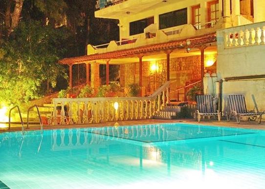 uma grande piscina em frente a uma casa em Econa Residence em Poros