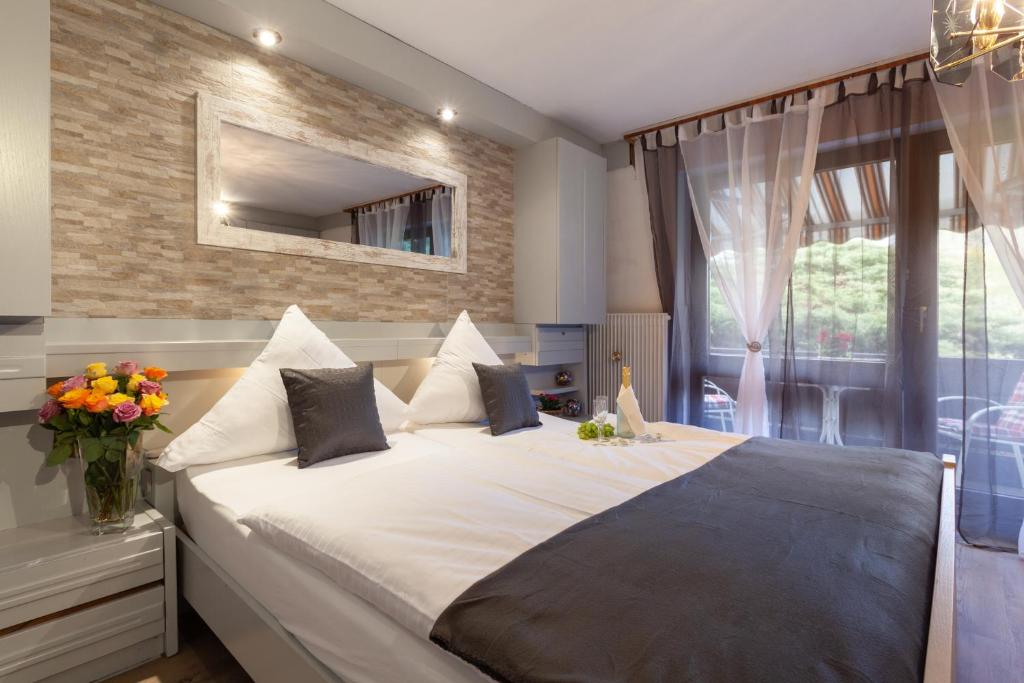 a bedroom with a large bed and a window at Hotel Petra in Baiersbronn