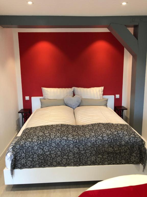 a bedroom with a large bed with a red headboard at Ferienanlage Vorauf - be lucky in Siegsdorf