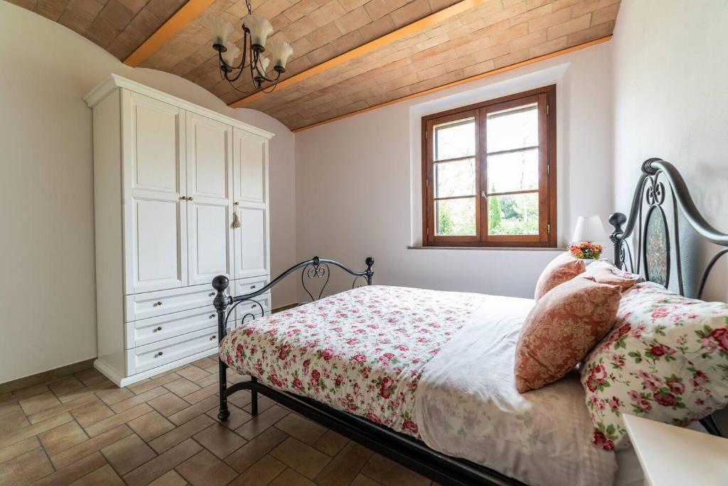 a bedroom with a bed and a dresser and a window at Appartamento nella Campagna di Certaldo Il Ciliegio in Certaldo