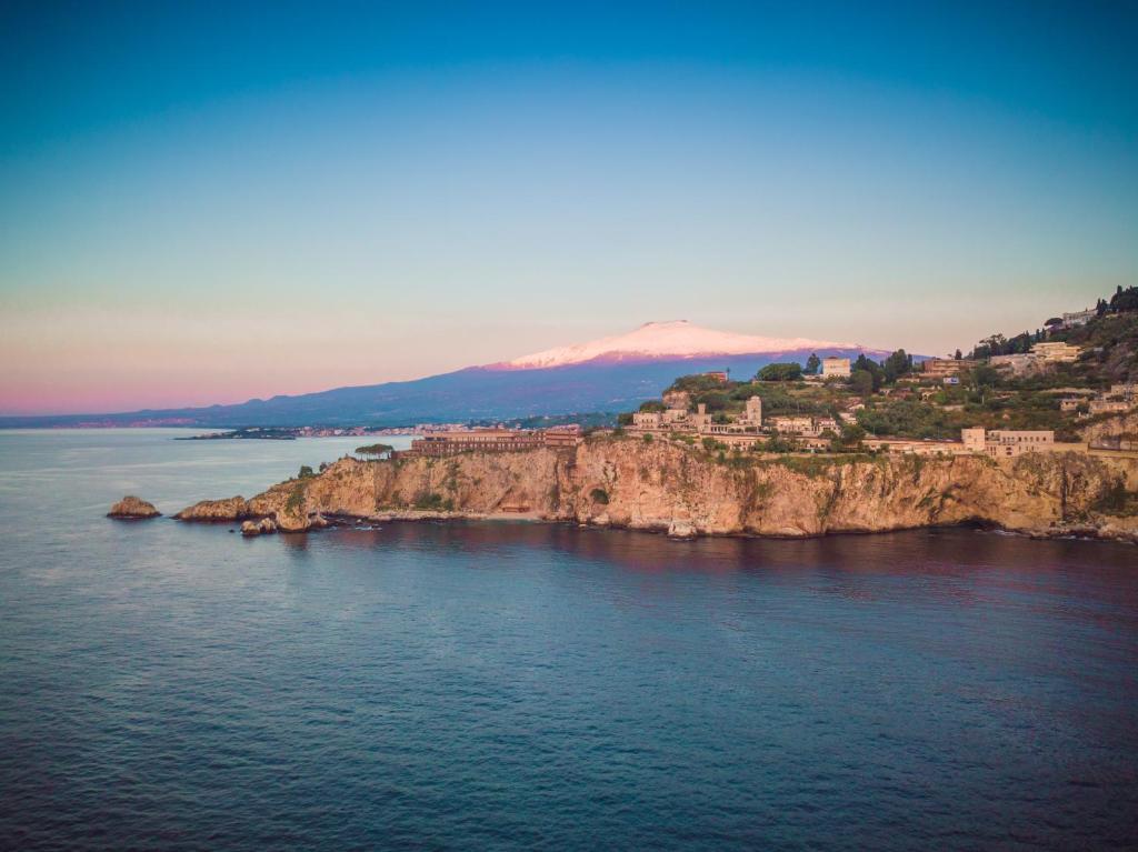 an island in the water with houses on it at Taormina Panoramic Hotel in Taormina