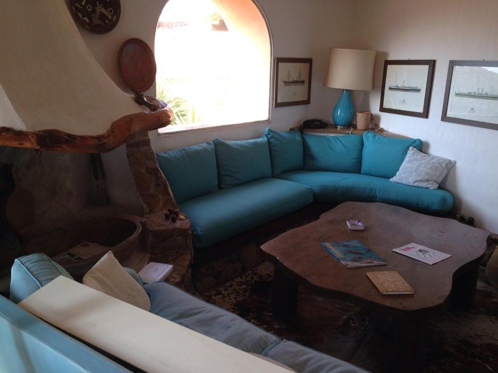un soggiorno con divano blu e tavolo di Pevero Golf ad Abbiadori