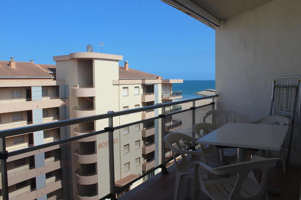 balcón con mesa, sillas y vistas al océano en Apartaments Lamoga - Boabi, en Torredembarra