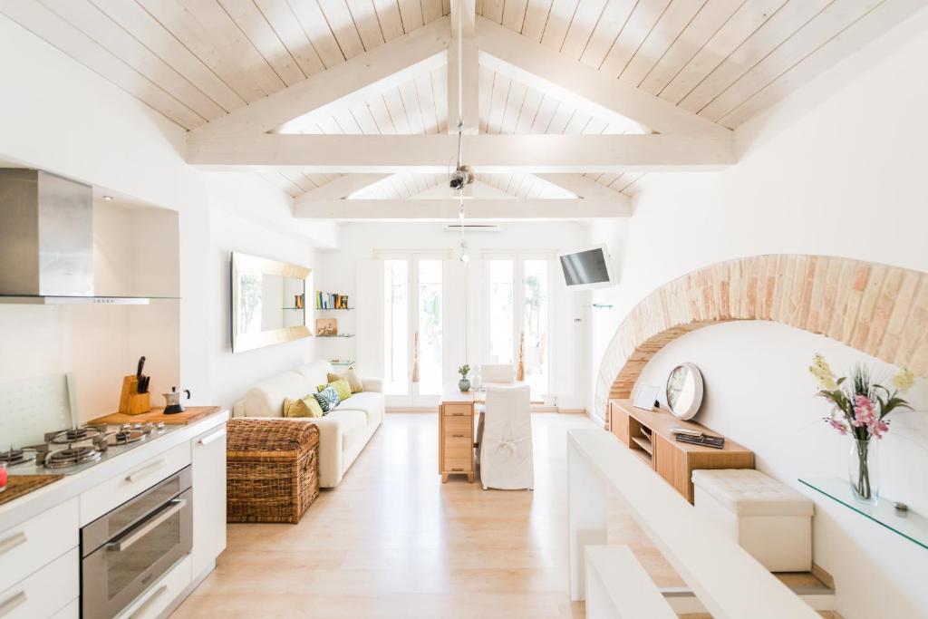 una cucina e un soggiorno con pareti bianche e soffitti in legno di Wonderful Apartment in the City Centre - Big Terrace & WiFi a Cagliari