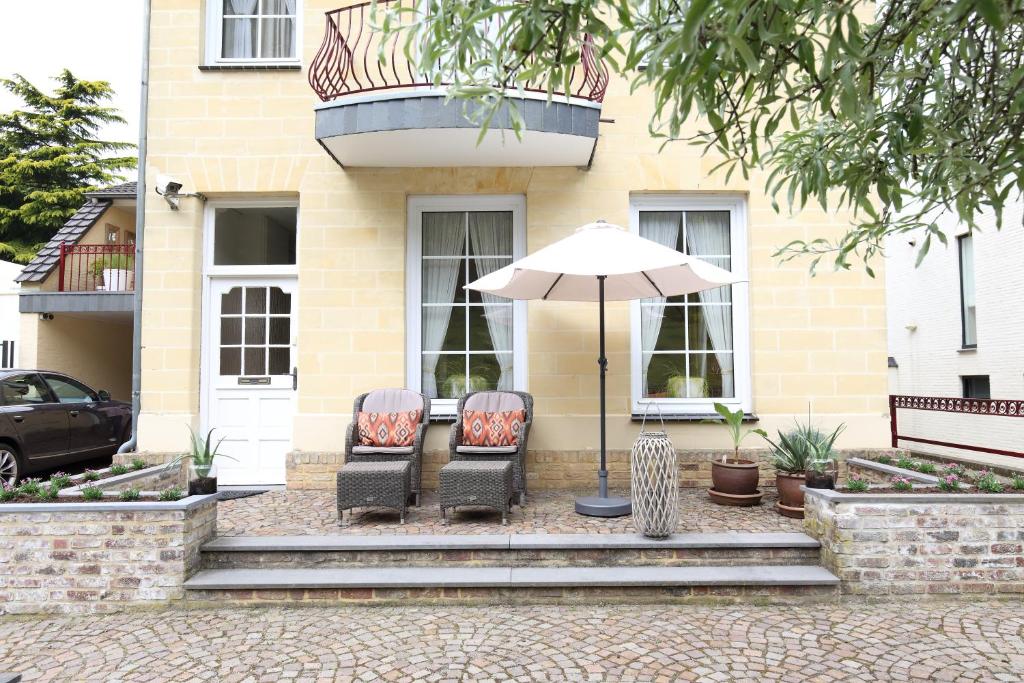 two chairs and an umbrella in front of a house at Appartement Scheepers in Valkenburg