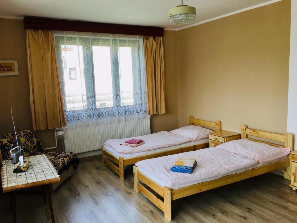 a room with three beds and a window at Rodinný RETRO domček in Dolný Kubín