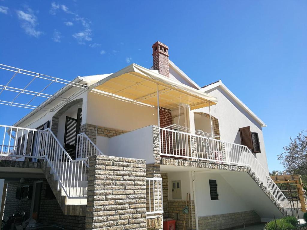 a white house with white railings at Apartments KUS Ugljan in Ugljan