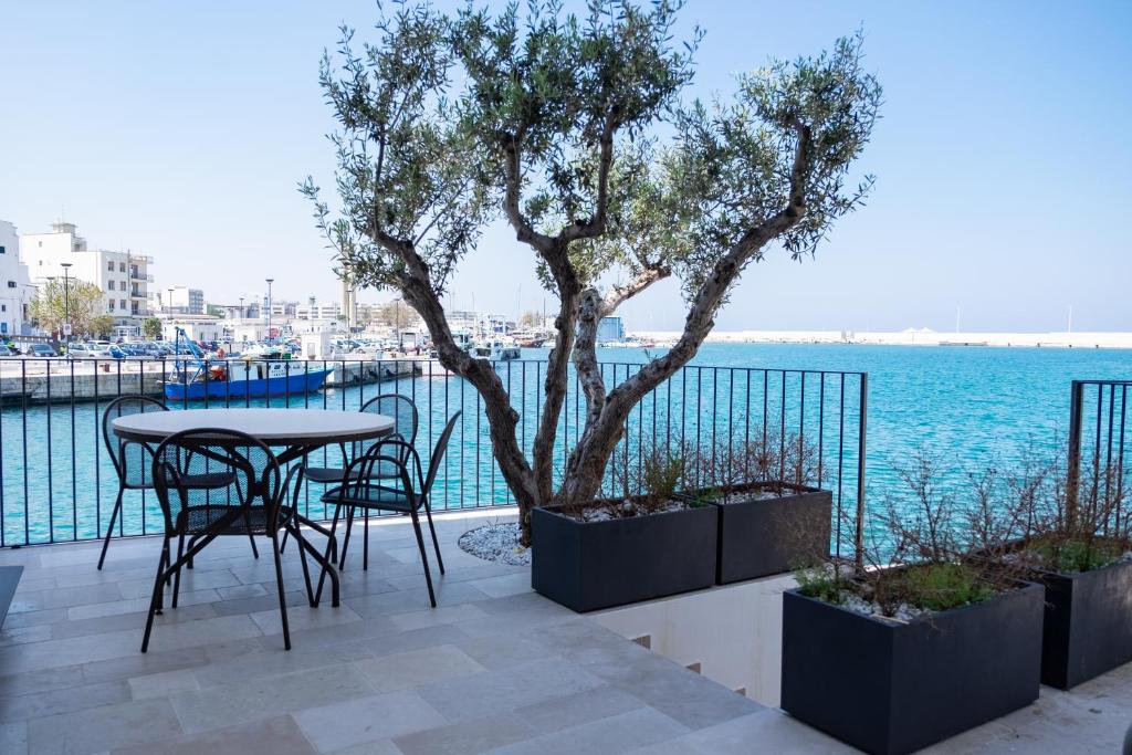 a table and chairs on a patio next to the water at La casa di Alice in Monopoli