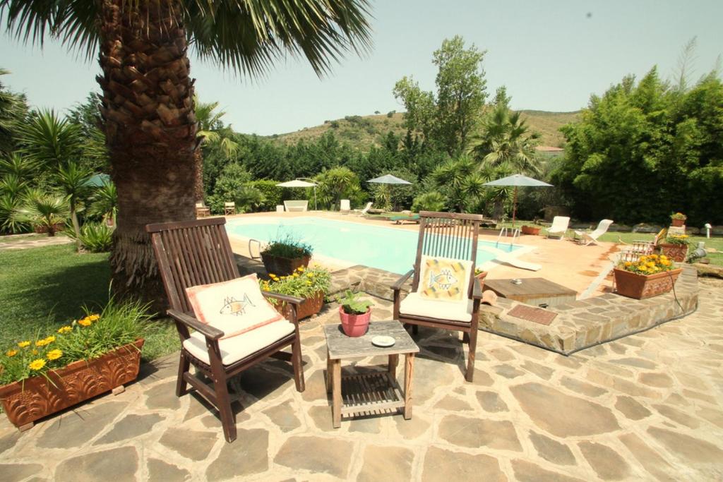 2 sillas y una mesa junto a la piscina en Villa Tresino Appartamenti, en Castellabate
