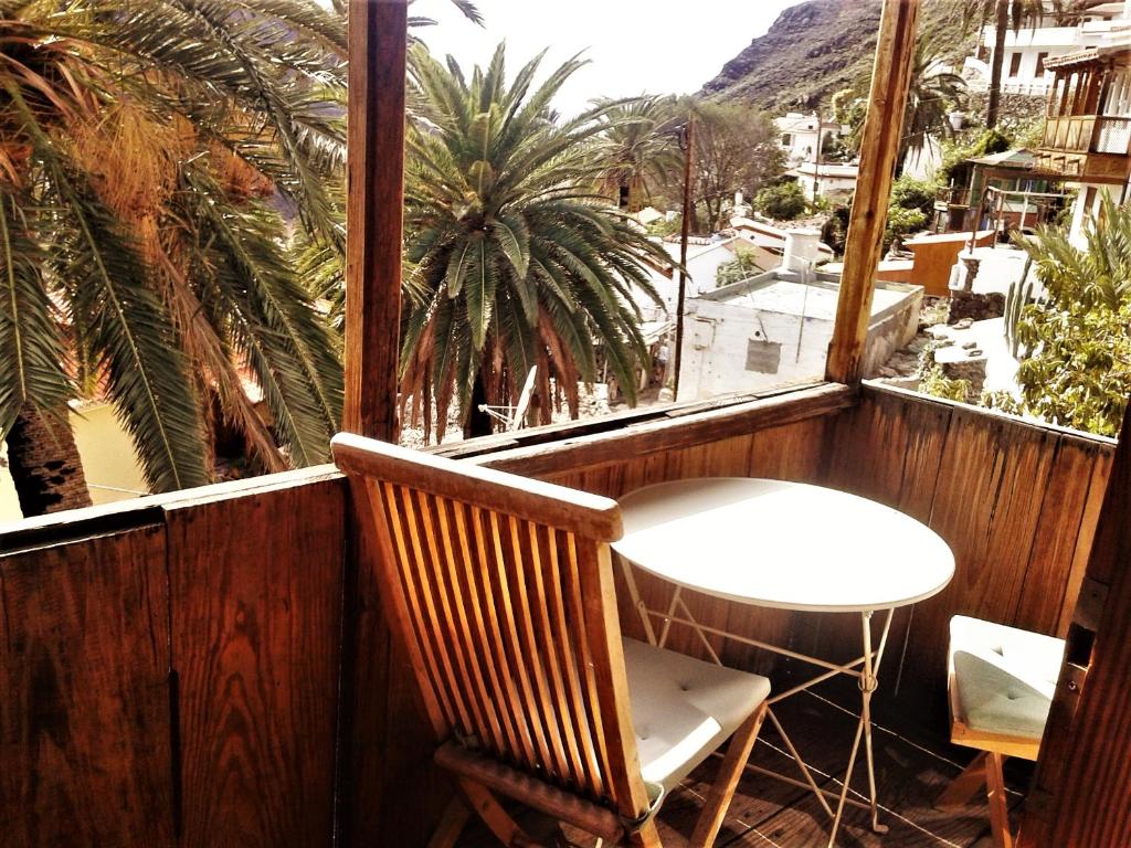 una mesa y una silla en un balcón con palmeras en Torre Azul, en Valle Gran Rey