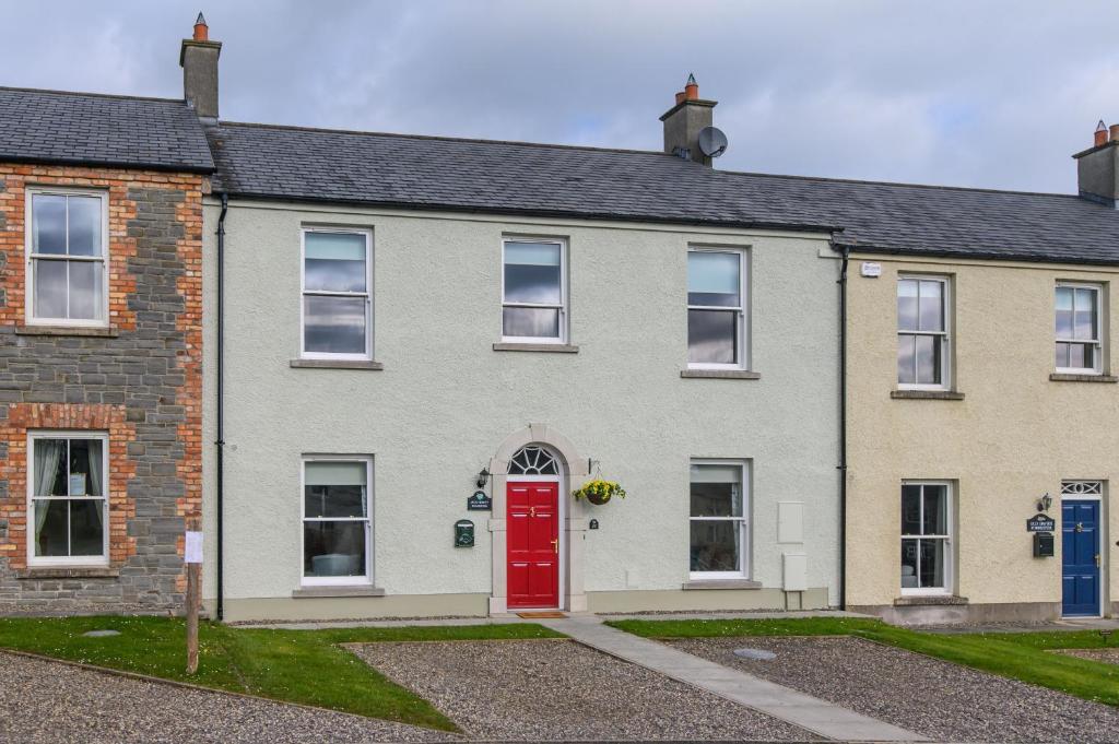 an old brick house with a red door at 20 village square Glaslough in Glaslough