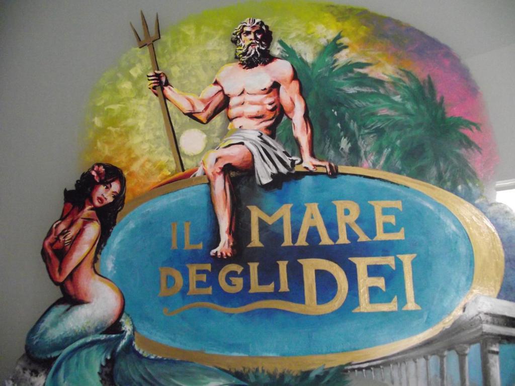 a painting of a man sitting on top of a sign at B&B Il Mare degli Dei in Letojanni