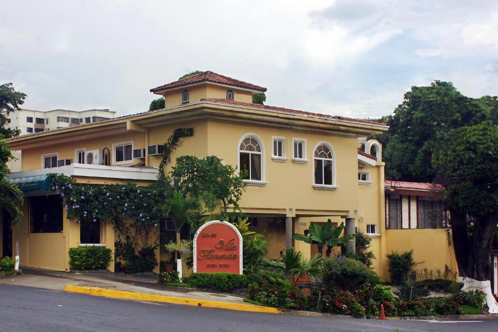 un edificio amarillo en la esquina de una calle en Hotel Villa Florencia Zona Rosa en San Salvador