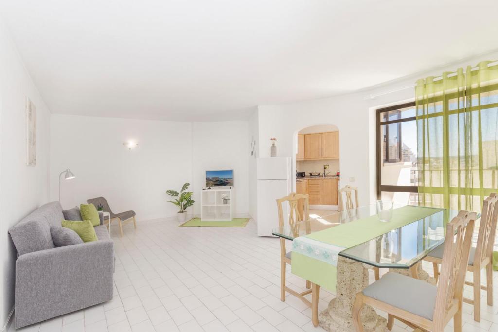 een keuken en woonkamer met een tafel en stoelen bij Esquina do Mar in Armação de Pêra