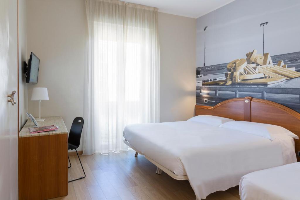 a bedroom with a bed and a dresser at B&B Hotel Pescara in Pescara