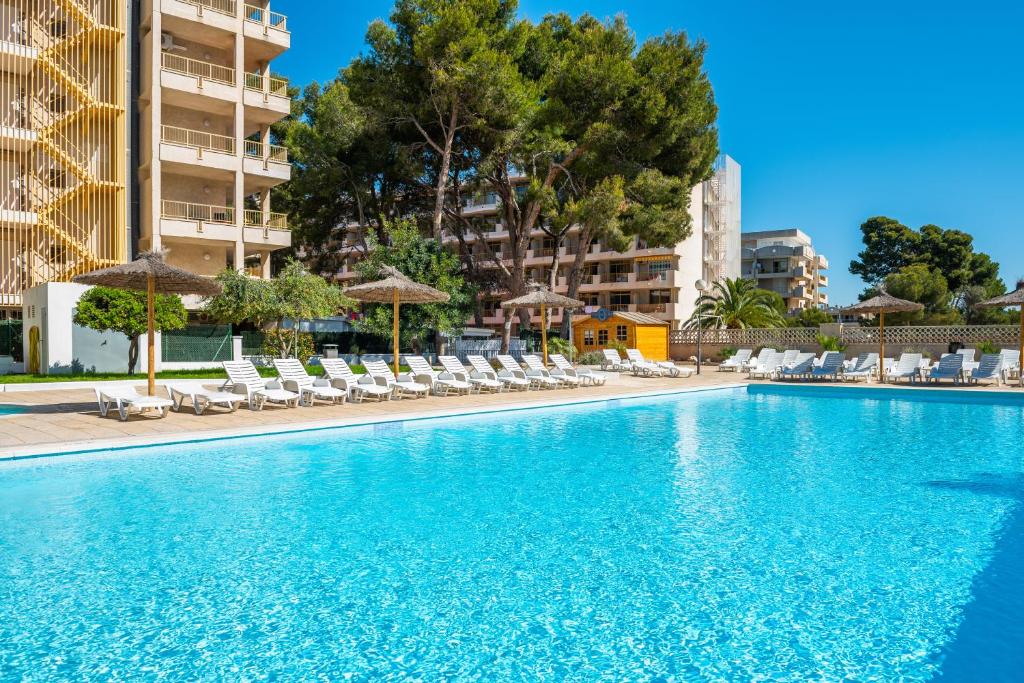 una piscina con sillas y sombrillas en un hotel en Salou Pacific, en Salou