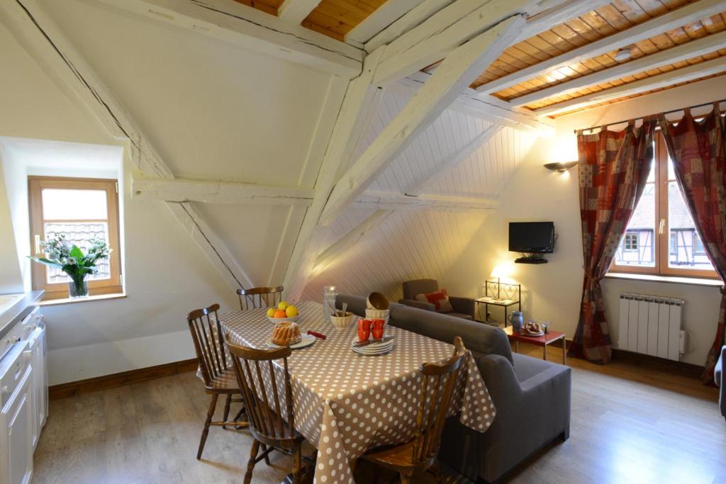 ein Wohnzimmer mit einem Tisch und einem Sofa in der Unterkunft RIBEAUVILLE city center - Gîte des Ménétriers, LES VIEILLES VIGNES - in Ribeauvillé