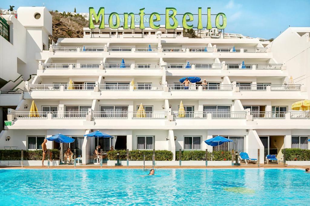 un hotel con piscina frente a un edificio en Servatur Montebello, en Puerto Rico de Gran Canaria