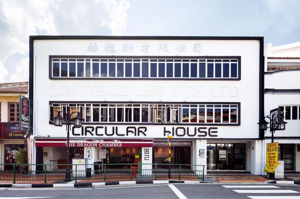 a white building with a sign that reads circular house at Circular House in Singapore