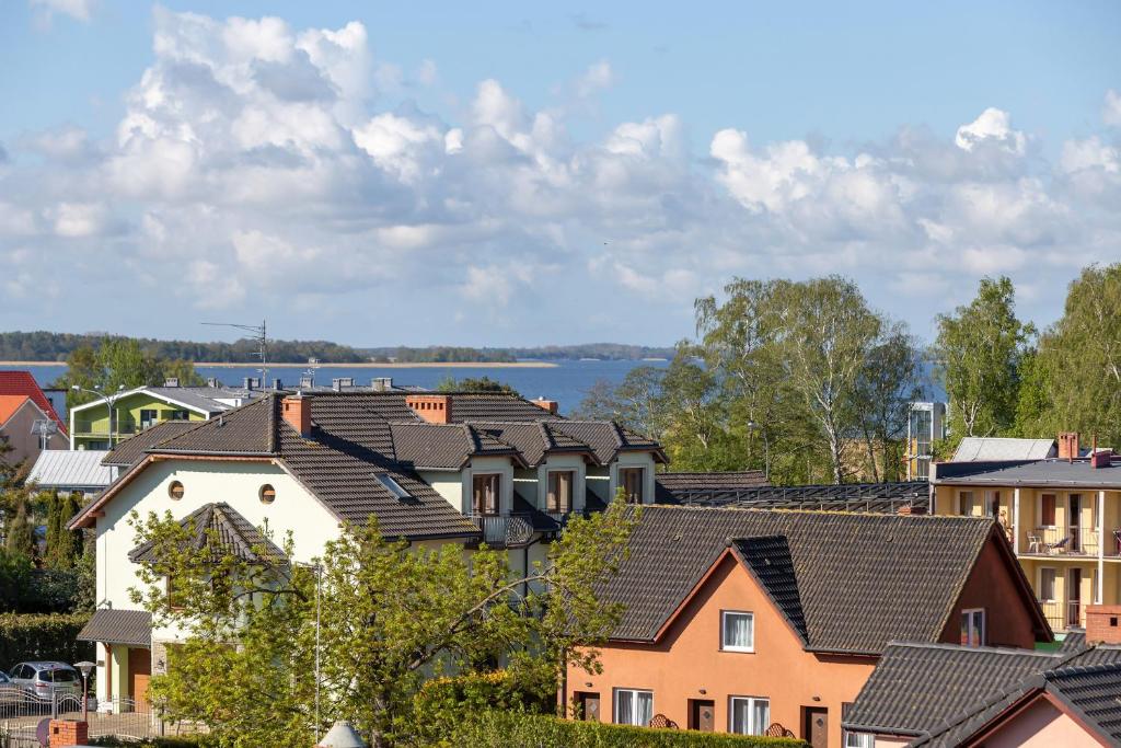 a group of houses with a lake in the background at Apartamenty Słoneczne Tarasy by Renters in Dziwnówek