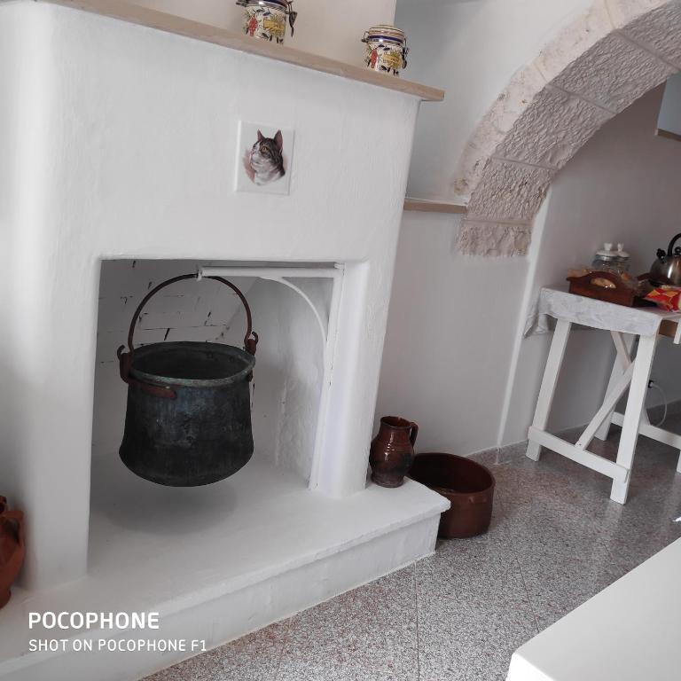 a fireplace with a bucket inside of it at Dimora Sumerano in Alberobello