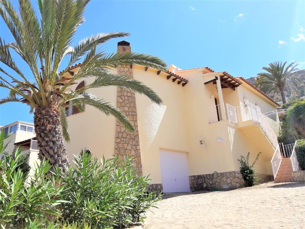 una casa con una palmera delante de ella en MARYVILLA 57, en Calpe