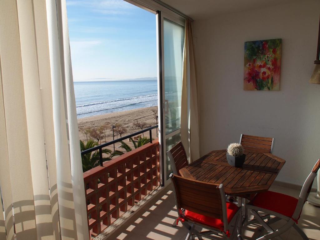 Un balcón con mesa y vista a la playa. en MIRAMAR 23A, en Roses