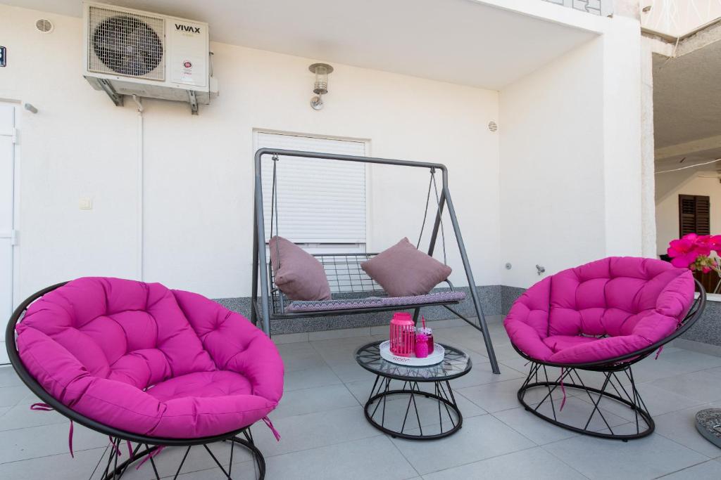 2 sillas rosas y una mesa en una habitación en Apartments Nana, en Podstrana