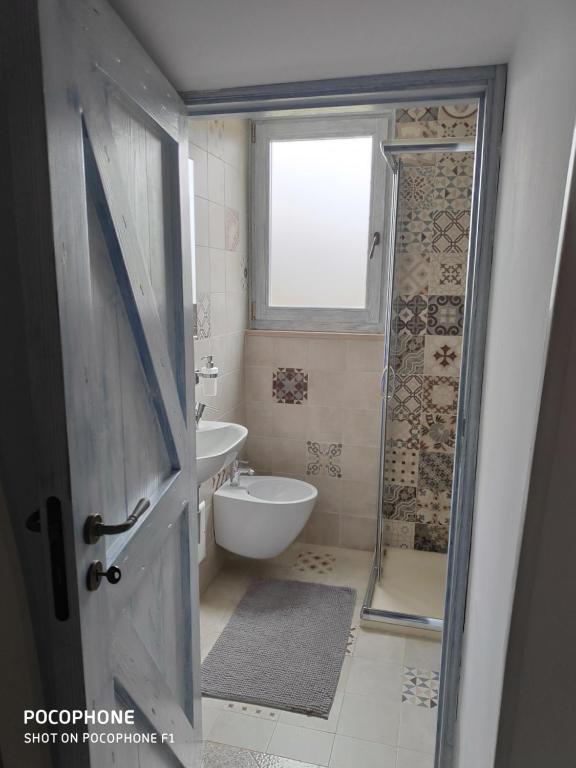 a bathroom with a shower and a toilet and a sink at Dimora Sumerano in Alberobello