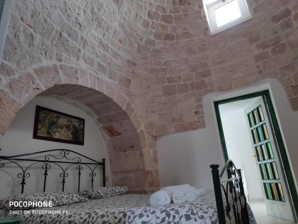 a bedroom with a bed in a brick wall at Dimora Sumerano in Alberobello