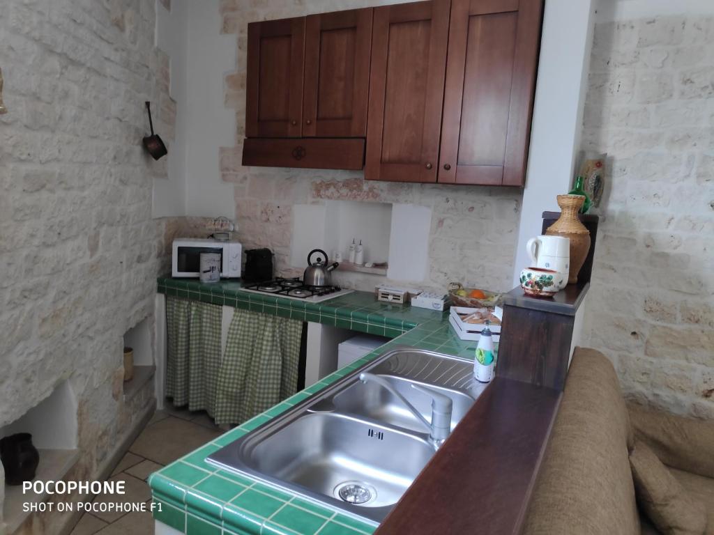 a kitchen with a sink and a counter top at Dimora Sumerano in Alberobello