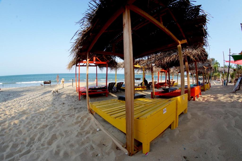 a row of tables on a beach with the ocean at Feel the Waves in Arugam Bay