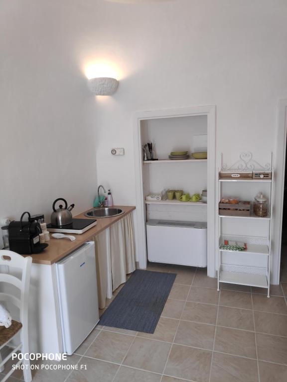 a kitchen with a counter and a refrigerator at Dimora Sumerano in Alberobello