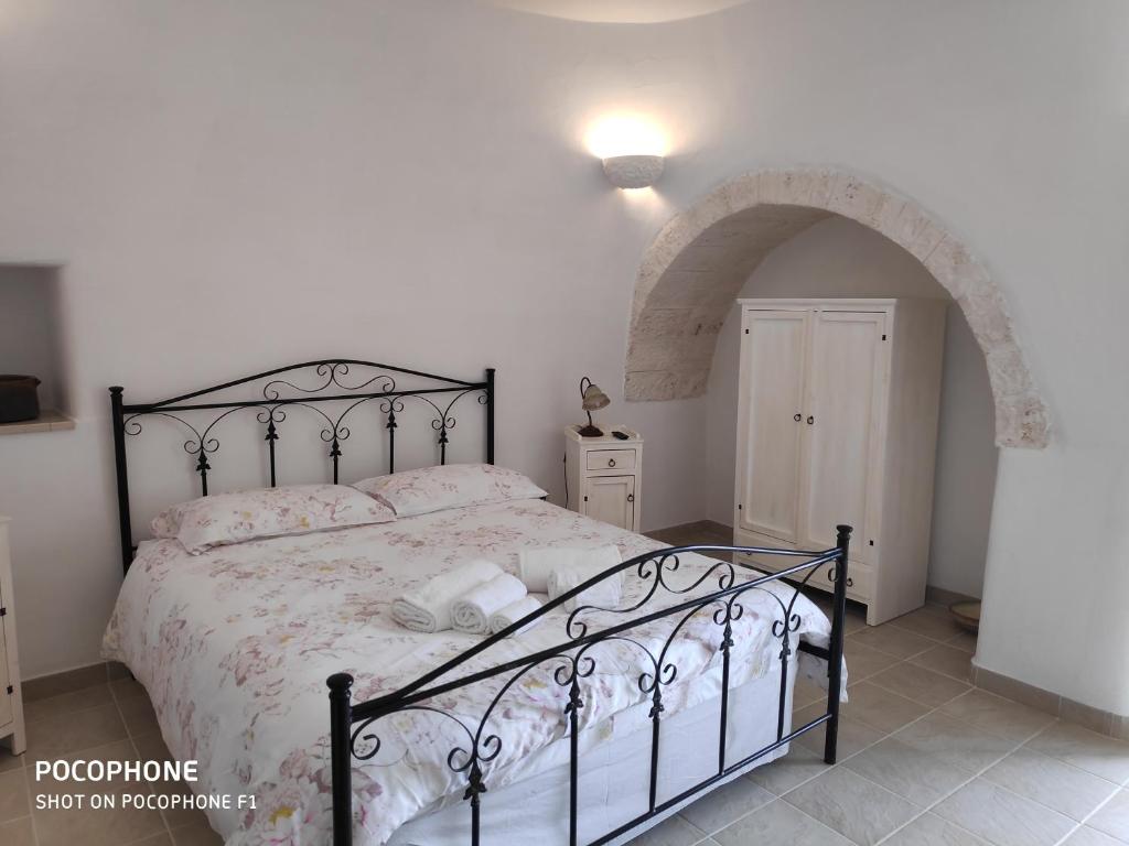 a bedroom with a black bed with an archway at Dimora Sumerano in Alberobello