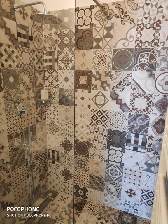 a bathroom with a tile floor with a shower at Dimora Sumerano in Alberobello