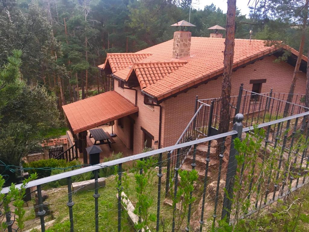 une maison avec une clôture devant elle dans l'établissement Apartamento chalet "el tornado" Cañon de rio lobos 15, à San Leonardo de Yagüe