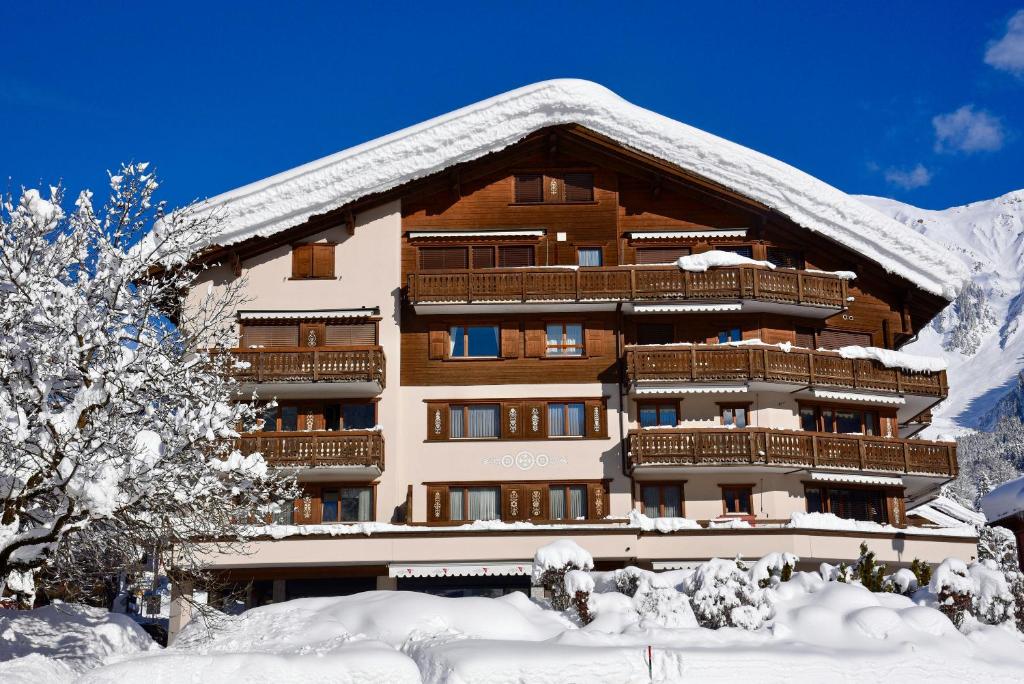 クロスタースにあるMonami Apartments Klosters, Apt. Hus Promenadeの屋根に雪が積もった大きな建物