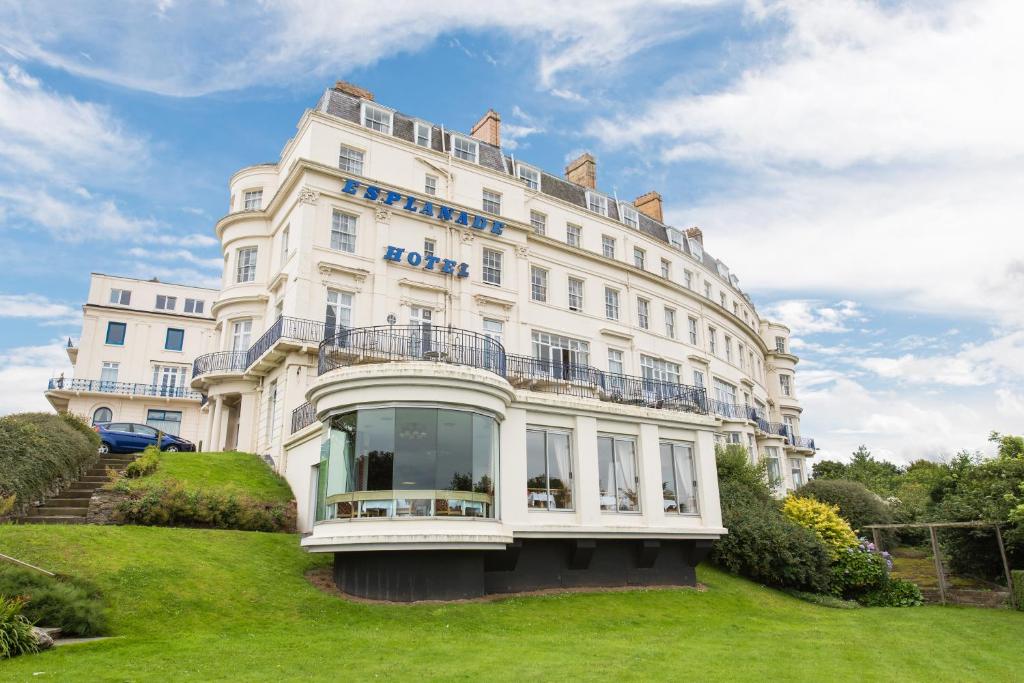 un gran edificio blanco en lo alto de un campo verde en The Esplanade Hotel, en Scarborough