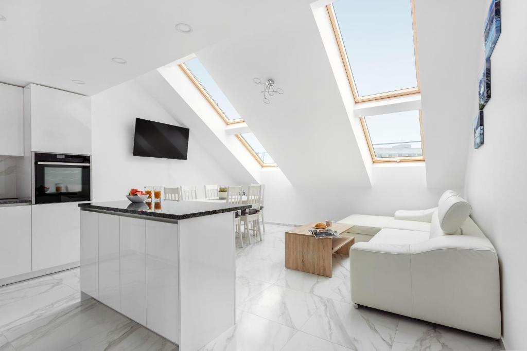 a living room with white walls and skylights at Luxurious Kaunas Basilica Apartment in Old Town by Urban Rent in Kaunas